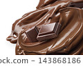 Two square chocolate pieces on glossy melted cocoa butter swirl 143868186