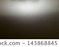 在強光照射下,垂直的拉絲金屬質感在黑暗中閃閃發光。 在強光照射下,垂直的拉絲金屬質感在黑暗中閃閃發光。 143868845