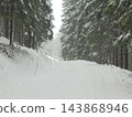 Czech spruce forest road in winter, snow-covered on overcast day 143868946