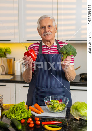 Senior old man showing seasonal vegetables in kitchen explaining healthy diet and nutrition choices Senior old man showing seasonal vegetables in kitchen explaining healthy diet and nutrition choices 143869431