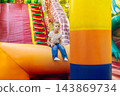 Sad boy sitting alone on inflatable playground 143869734