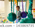 Child playing on soft obstacle course in indoor playground 143869735