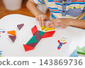 Child assembling geometric shapes for educational activity 143869736