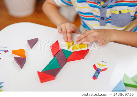 Child assembling geometric shapes for educational activity 143869736