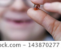 Child holding a freshly lost tooth between fingers 143870277