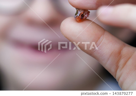 Child holding a freshly lost tooth between fingers Child holding a freshly lost tooth between fingers 143870277
