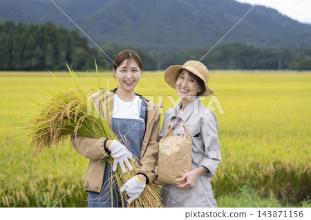 一位女稻農面帶微笑,直視鏡頭。 一位女稻農面帶微笑,直視鏡頭。 143871156