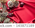 Christmas ornaments and frosted pinecones on red fabric 143871189
