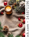 Christmas candle and red ornaments on a cozy knitted blanket 143871196