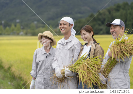 兩代農民臉上都洋溢著笑容,種著稻米。 兩代農民臉上都洋溢著笑容,種著稻米。 143871261