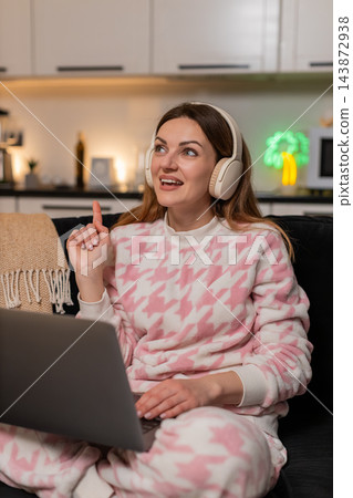 Adult woman with laptop and headphones gets creative idea during remote work session smiles inspired 143872938