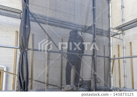 一名男性工匠正在進行外牆翻新工程的基礎工作。 一名男性工匠正在進行外牆翻新工程的基礎工作。 143873125