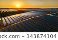 Aerial view of extensive photovoltaic panel arrays spreading across rolling hills in warm golden evening light. 143874104
