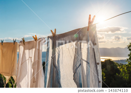 Sunlit Laundry Hanging Beside a Mountain Lake Sunlit Laundry Hanging Beside a Mountain Lake 143874110