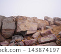 Reddish-purple volcanic rocks piled up in the mist; a landscape of rocky outcrops with ample empty space. 143874197