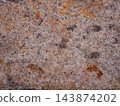 The surface of the natural stone is covered with fine grains; the stone has a pale pink texture. 143874202