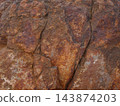 Cracked reddish-brown rock surface, a background material with a Martian-like texture. 143874203
