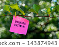 Paper note reading DIGITAL DETOX attached to leafy green plant. Suitable for digital detox, screen-free lifestyle technology 143874943