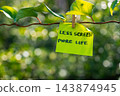 Paper note with LESS STRESS MORE LIFE message against green leafy background. Suitable for digital detox, screen-free lifestyle technology break mindfulness. 143874945