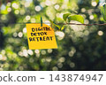 Paper note with DIGITAL DETOX RETREAT message against green leafy background. Suitable for digital detox, screen-free lifestyle technology break mindfulness. 143874947