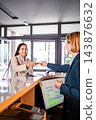 Guest receiving key card at hotel reception desk 143876632