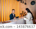 Guest checking in at hotel reception desk 143876637