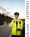 Police officer operating a drone for roadside surveillance 143876643