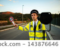 Police officer holding stop sign during roadside traffic enforcement 143876646