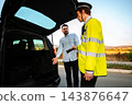 Police officer inspecting a car trunk during a roadside traffic stop 143876647
