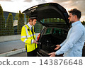 Traffic police officer inspecting car trunk during roadside stop 143876648