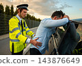Police officer frisking a man during a roadside traffic stop 143876649
