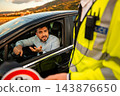 Driver explaining himself to a police officer during a roadside traffic stop 143876650
