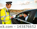 Police officer writing a traffic citation during a roadside stop 143876652