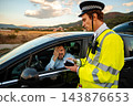 Police officer issuing traffic ticket to frustrated driver during roadside stop 143876653