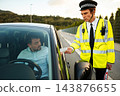 Police officer handing a traffic ticket to a driver during a roadside stop 143876655