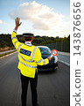 Police officer signaling a driver during a roadside traffic stop 143876656