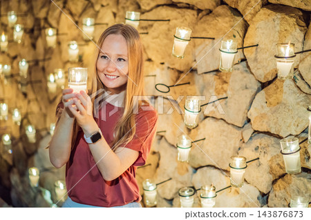 Happy visitor with a votive candle at a Mexican cultural event. 143876873