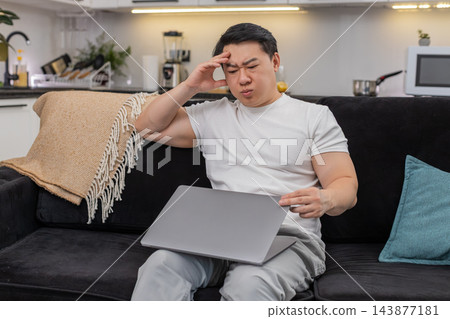 Asian man snaps laptop shut tired waves hand enough closes eyes a moment then leans back with relief Asian man snaps laptop shut tired waves hand enough closes eyes a moment then leans back with relief 143877181