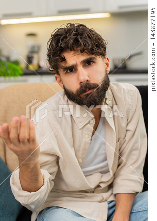 Indian man skeptical squinting eyes looking at camera doubting text feels confused unsure reaction Indian man skeptical squinting eyes looking at camera doubting text feels confused unsure reaction 143877195