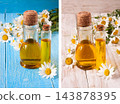 bottle with essential oil and fresh chamomile flowers on a bluewooden background 143878395