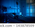 Sleeping patient under monitoring equipment, low blue tones emphasize quiet clinical environment and vigilance of night staff image suggests medical observation and fragile rest 143878509