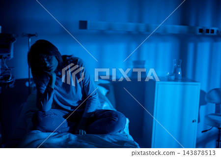 Hospital patient seeks family contact. Individual in hospital calls loved ones late at night. Hospitalized figure uses phone to reach out to support during lonely hours Hospital patient seeks family contact. Individual in hospital calls loved ones late at night. Hospitalized figure uses phone to reach out to support during lonely hours 143878513