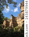 Vertical earth pillar and layered cliffs beneath leafy canopy at Pha Chor, Chiang Mai, Thailand 143879944