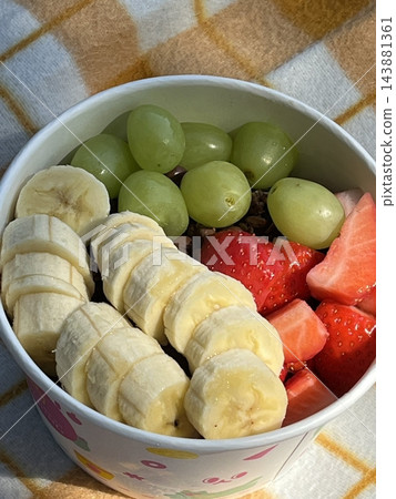 Swirled yogurt ice cream dessert served in a cup, smooth creamy texture with glossy surface, topped with fresh fruit pieces, highlighting its refreshing and inviting appearance in detail Swirled yogurt ice cream dessert served in a cup, smooth creamy texture with glossy surface, topped with fresh fruit pieces, highlighting its refreshing and inviting appearance in detail 143881361