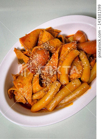 Spicy Korean tteokbokki with chewy rice cakes in a vibrant red sauce, topped with sesame seeds and green onions. A popular street food known for its addictive flavor and satisfying texture. Spicy Korean tteokbokki with chewy rice cakes in a vibrant red sauce, topped with sesame seeds and green onions. A popular street food known for its addictive flavor and satisfying texture. 143881399