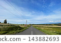 Kamifurano Town, Hokkaido: A straight road running through the hills and breathtaking scenery with its ups and downs. 143882693