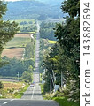 Kamifurano Town, Hokkaido: A straight road running through the hills and breathtaking scenery with its ups and downs. 143882694