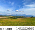 Kamifurano Town, Hokkaido: A straight road running through the hills and breathtaking scenery with its ups and downs. 143882695