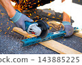 Worker cutting metal with many sharp sparks using equipments to cut iron 143885225