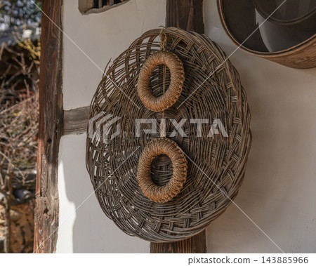 Traditional Korean Woven Baskets and Straw Rings on a Wall Traditional Korean Woven Baskets and Straw Rings on a Wall 143885966